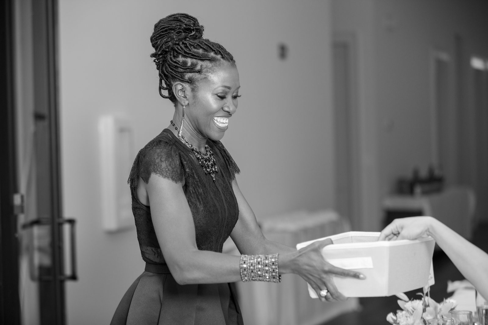 Kwavi handing a gift box to a guest